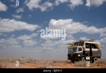 Un veicolo terrestre che viaggiano intorno al secchi e aridi del Kenia settentrionale. Africa Foto Stock