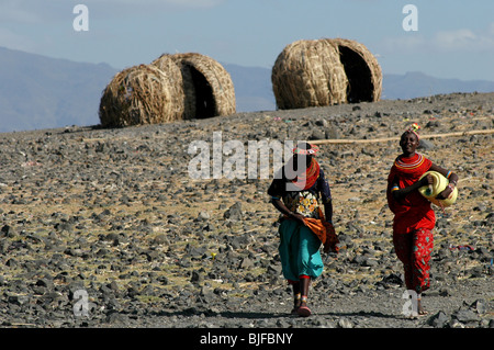 Le donne dal tradizionale El-Molo tribù a piedi fino al bordo delle acque del lago Turkana. Kenya settentrionale, Kenya, Africa Foto Stock