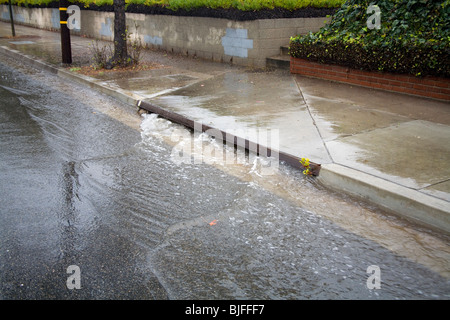 Le forti piogge hanno portata strade giù in strada grondaie e scaricatori di piena, Culver City, California, Stati Uniti d'America Foto Stock