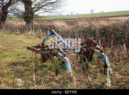 Un vecchio pezzo di macchinario agricolo lasciato in un angolo di un campo in Norfolk, Regno Unito. Foto Stock