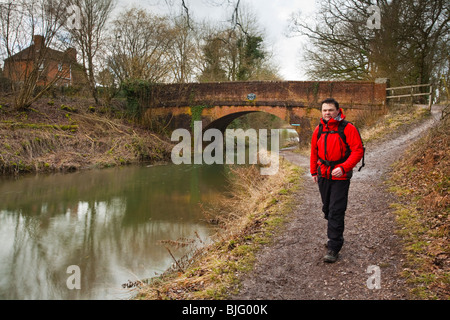 Il camminatore maschio sulla strada alzaia del Basingstoke Canal dalla quercia Broak ponte vicino Odiham, Hampshire, Regno Unito Foto Stock