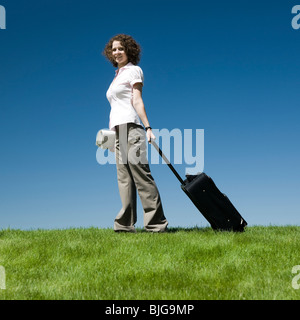 Imprenditrice con una valigia scorrevole Foto Stock