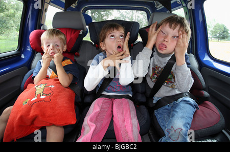 I bambini in una vettura facendo facce silly Foto Stock