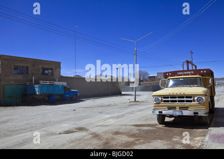 Vista panoramica di un vuoto street e vecchi camion a Uyuni vicino l'arido deserto di sale. Un rurale città fantasma nel Altiplano (Salar). Foto Stock