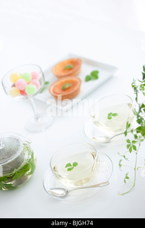 Il tè alle erbe, un bicchiere di Candy e crostate Foto Stock