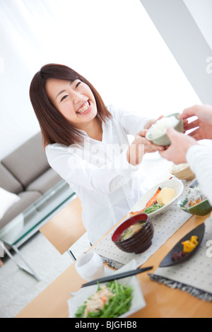 Donna passando tazzina Foto Stock