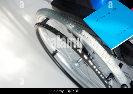 Sedia a rotelle e libretti di pensione Foto Stock