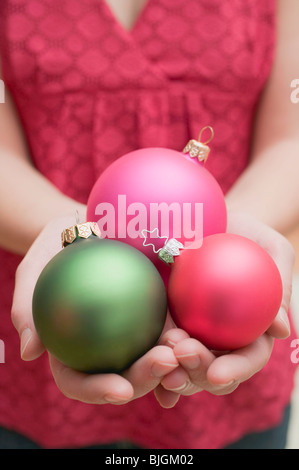 Donna che mantiene baubles di natale - Foto Stock