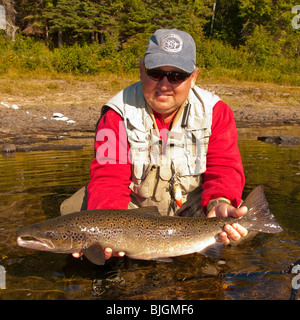 NEW BRUNSWICK, Felice Pescatore a mosca il rilascio di salmone atlantico sulla Miramichi River. Foto Stock