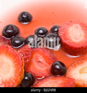 Fragole a fette e tutta i mirtilli in sciroppo di sfondo di cibo. Foto Stock