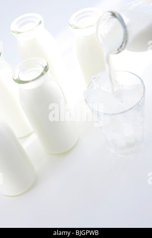 Bottiglie di latte e di latte versato in vetro Foto Stock