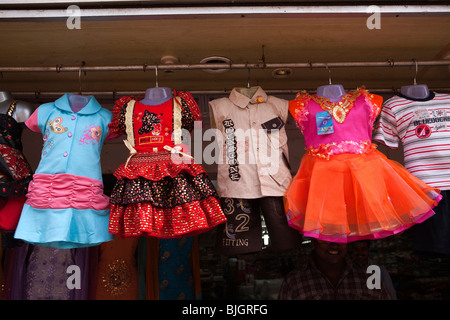 India Kerala, Calicut, Kozhikode, SM Street, pacchiano colorato i bambini gli abiti appesi al di fuori del negozio di abbigliamento Foto Stock