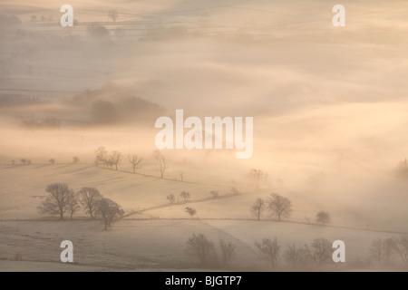 La Hope Valley è avvolta nella nebbia all'alba nel Parco Nazionale di Peak District Foto Stock