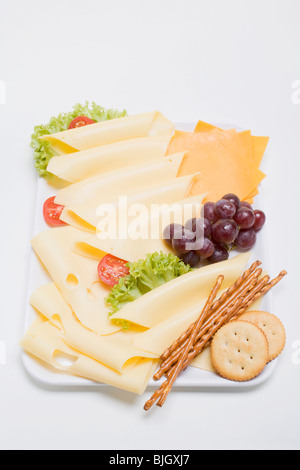 Un vassoio di formaggi con uve e stuzzichini - Foto Stock