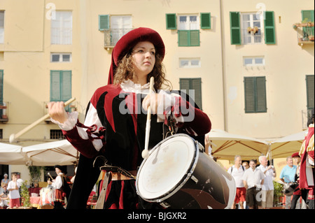 Città italiana di Lucca. I giovani locali batterista donna in costume medievale street pageant festival. Toscana, Italia Foto Stock