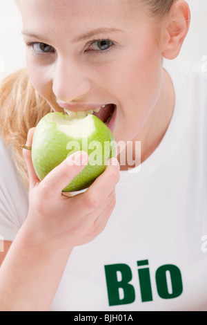 Donna di mangiare verde biologico apple - Foto Stock