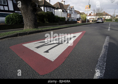 I bambini di attraversamento addolorato di avvertimento sulla strada che mostra 2 scolari tenendo le mani come un avvertimento per i conducenti Foto Stock