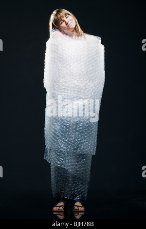 Donna avvolta in Bubble wrap Foto Stock