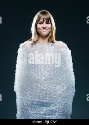 Donna avvolta in Bubble wrap Foto Stock