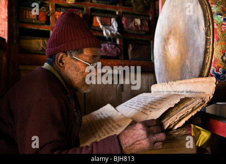 Un tibetano monaco buddista legge testi sacri nel villaggio di SAMDO sul intorno il MANASLU TREK - REGIONE NUPRI, NEPAL Foto Stock