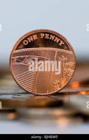 Ritratto di un penny pezzo sul tavolo con fuori fuoco monete in primo piano Foto Stock