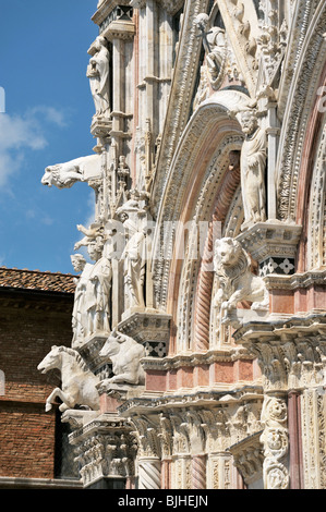 Cattedrale di Siena, Toscana, Italia. La caramella-striped facciata principale del duomo adornata con bestie e intricati intarsi Foto Stock