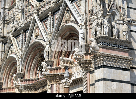 Cattedrale di Siena, Toscana, Italia. La caramella-striped facciata principale del duomo adornata con bestie e intricati intarsi Foto Stock