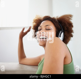 Donna ascoltare musica sulle cuffie Foto Stock