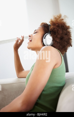 Donna ascoltare musica sulle cuffie Foto Stock