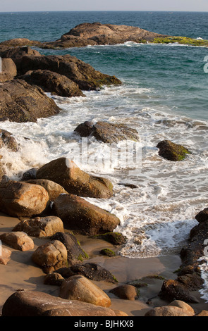 India Kerala, Kovalam, onde la laminazione in appartata baia rocciosa Foto Stock