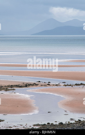 Vista sulla baia di Applecross a Rasaay e isola di Skye con sabbia rossa e cloud pesanti Foto Stock