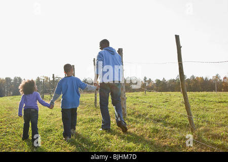 Padre e figli a piedi Foto Stock