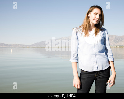 Donna in piedi accanto a un lago Foto Stock
