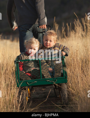 Padre tirando i bambini in carro Foto Stock