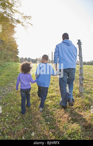 Padre e figli a piedi Foto Stock