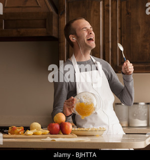 Uomo di cottura e ascolto di musica Foto Stock