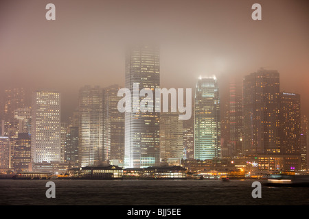 Ufficio blocchi illuminata di notte a Hong Kong, Cina. Questa popolosa città ha una massiccia impronta di carbonio. Foto Stock