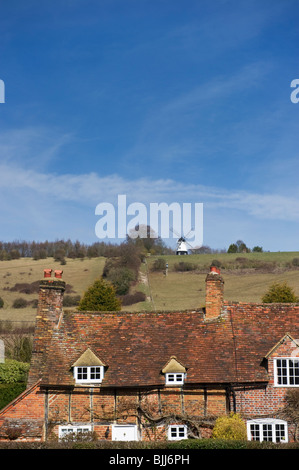 Una vista in lontananza il mulino a vento di Turville noto come Cobstone Mill e tradizionale cottage inglese in primo piano. Foto Stock