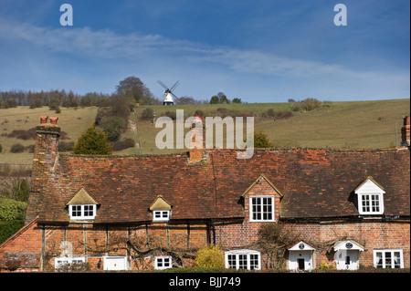 Una vista in lontananza il mulino a vento di Turville noto come Cobstone Mill e tradizionale cottage inglese in primo piano. Foto Stock