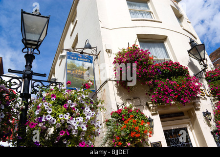 Inghilterra, East Sussex, Brighton Lanes in vecchio stile lampione lampione fuori del Sussex Pub con fiori in scatole di finestra Foto Stock