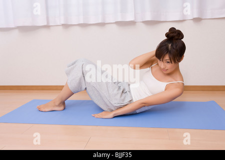 Giovane donna facendo sit ups Foto Stock