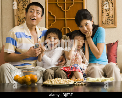 Scioccato la famiglia di guardare la televisione Foto Stock