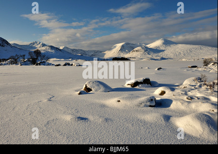 Vasta distesa di congelati coperti di neve sul lago con sfondo innevato delle montagne e il cielo blu scuro Foto Stock