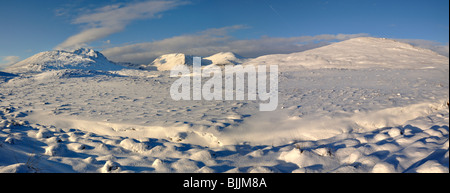 Panorama di lontane montagne innevate e cielo blu che si vede attraverso una vasta distesa di profondamente coperta di neve la brughiera e deviati neve Foto Stock