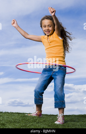 Ragazza che gioca con hula hoop all'aperto Foto Stock