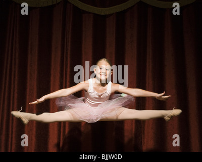 Ballerina ragazza sul palco che saltava e sorridente Foto Stock