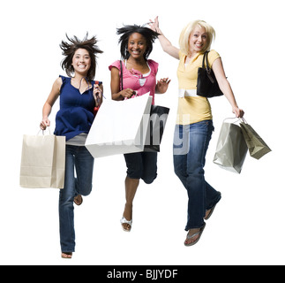 Tre donne con le borse della spesa sorridente e saltando Foto Stock