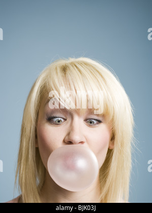 La donna a soffiare bolle con la gomma da masticare Foto Stock