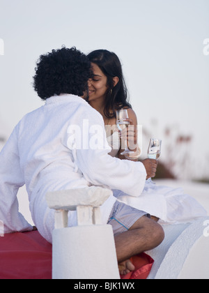 Giovane baciare e snuggling all aperto con champagne flauti Foto Stock