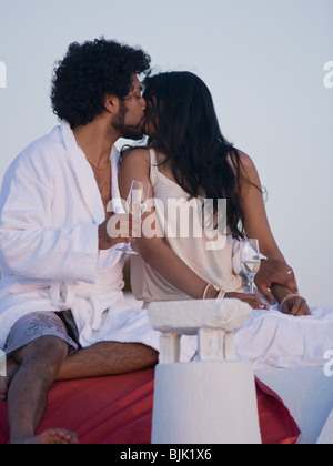 Giovane baciare e snuggling all aperto con champagne flauti Foto Stock